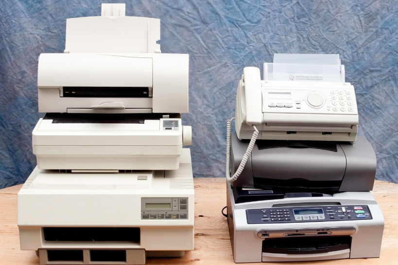 Old printers, fax machines, and office electronics ready for junk removal and responsible disposal.